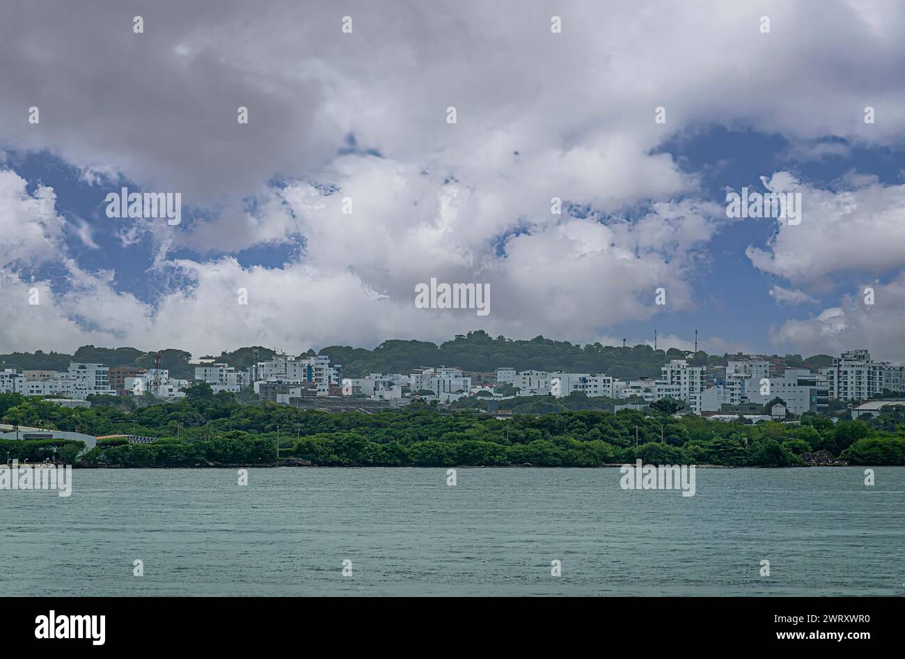Cartagena, Kolumbien - 25. Juli 2023: Grüne Hügel mit weißen Gebäuden auf der Isla Manzanillo und darüber hinaus, Ostküste von Bahia de Caragenas unter blauem C Stockfoto