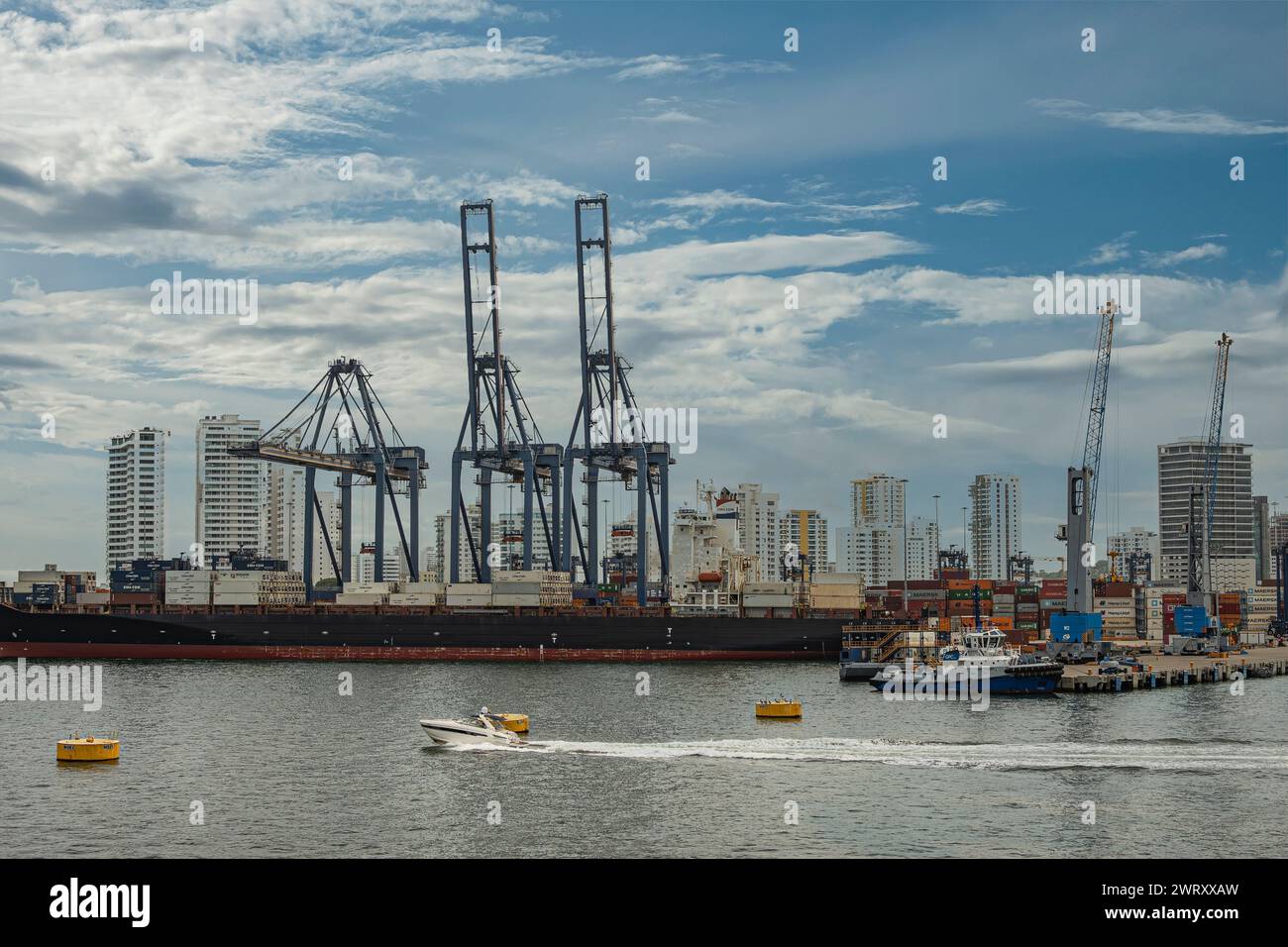 Cartagena, Kolumbien - 25. Juli 2023: CMA CGM America dockte Containerschiff am SPRC-Containerterminal unter blauer Wolkenlandschaft an, hohe Gebäude, Stadtbild Stockfoto