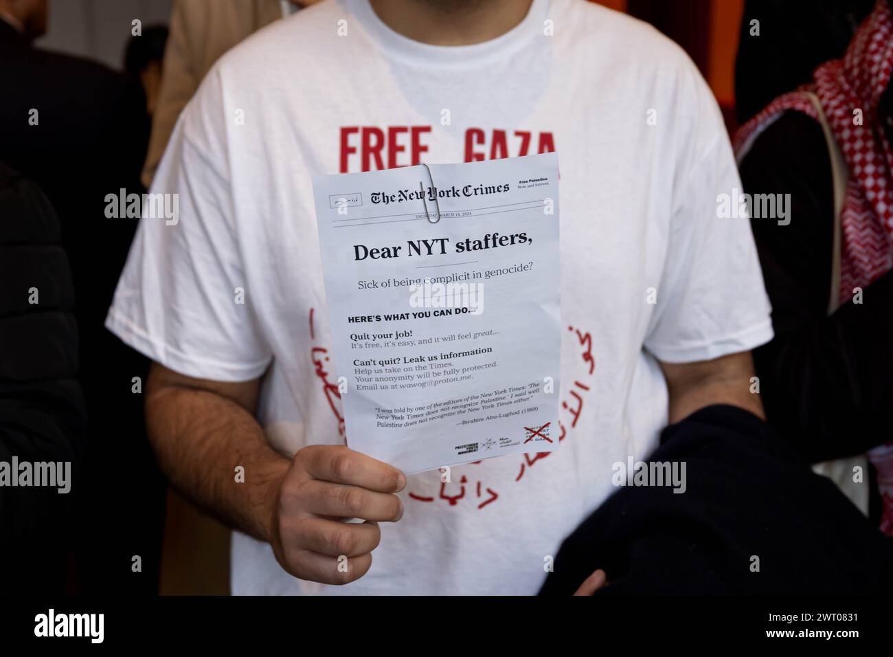 New York, Usa. März 2024. Ein pro-palästinensischer Demonstrant verteilt Flugblätter an Büroangestellte, die in die Lobby der Büros der New York Times kommen, während einer Aktion, die die Berichterstattung der Zeitung über den Israel-Hamas-Krieg am 14. März 2024 in New York City kritisiert. Die Demonstranten blockierten die Sicherheitseingänge für fast zwei Stunden, was zu etwa 100 Verhaftungen führte. (Foto: Michael Nigro/Pacific Press) Credit: Pacific Press Media Production Corp./Alamy Live News Stockfoto