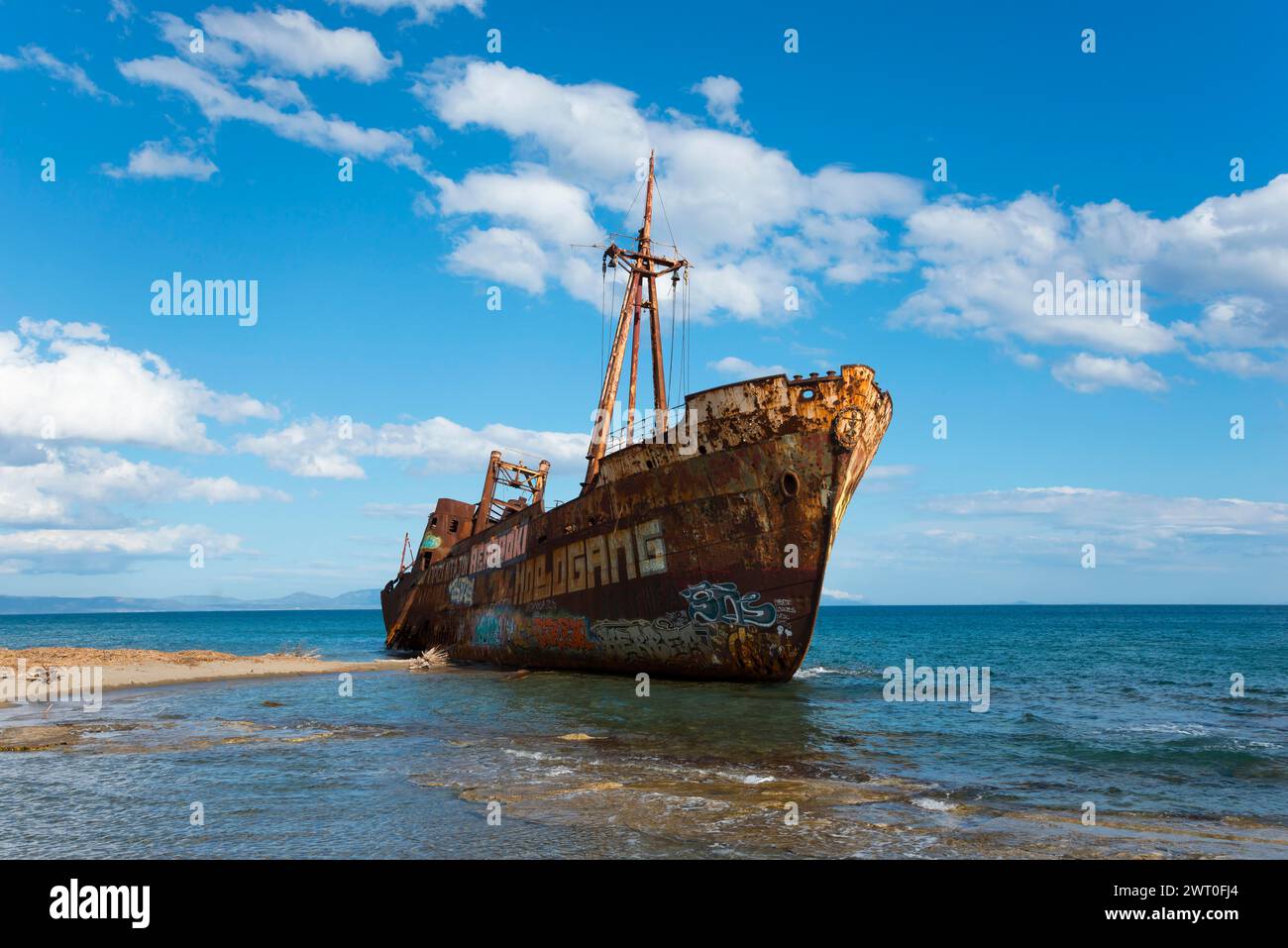 Ein rostiger Schiffsrumpf mit Graffiti liegt verlassen vor einem leuchtend blauen Himmel am Meer, Schiffswrack Dimitrios, Glyfada Beach, Selinitsa, Gythio Stockfoto