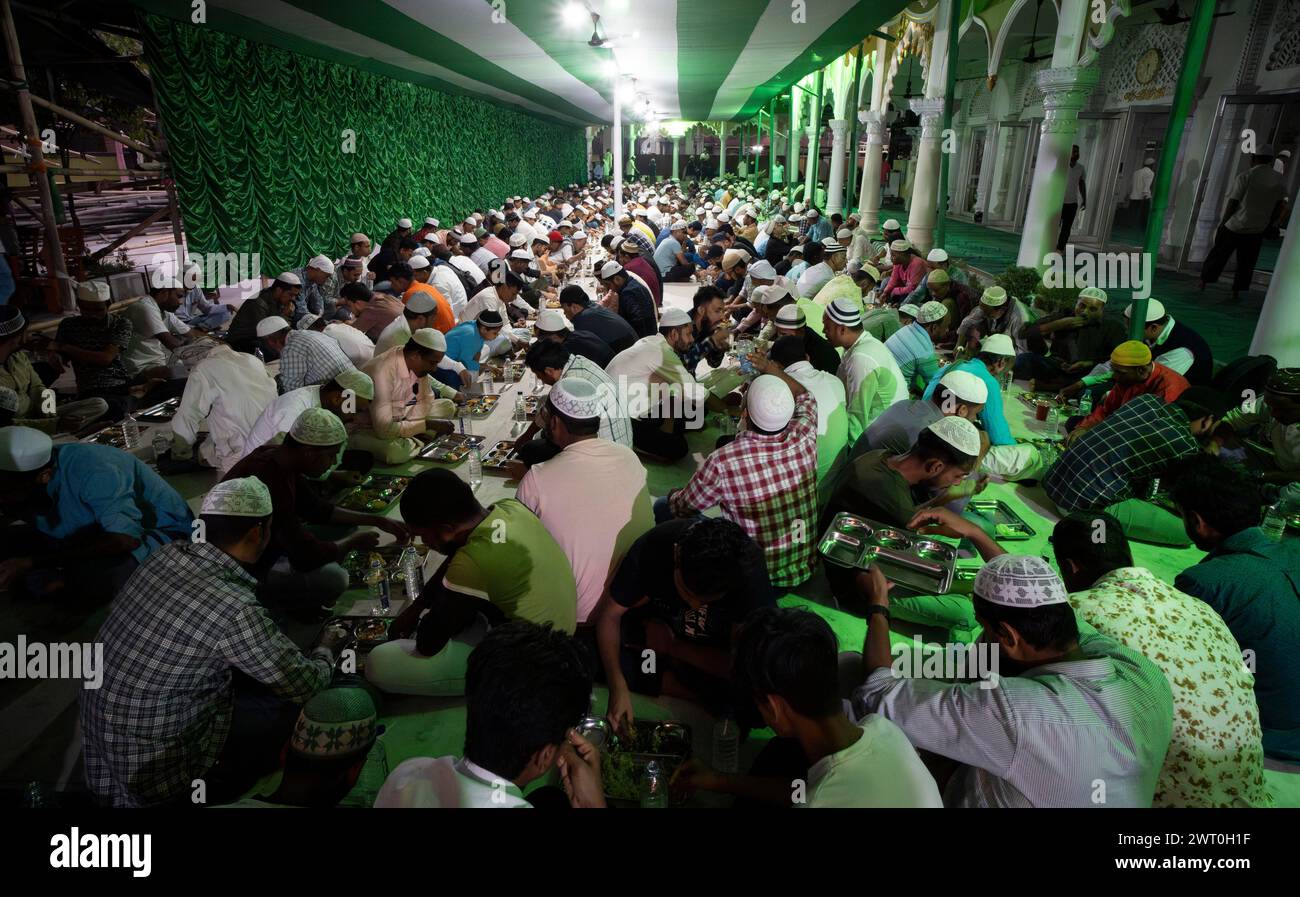 Muslimische Gläubige essen zusammen „iftar“, um ihr Fasten während des heiligen Monats Ramadan zu brechen, am 13. März 2024 in Guwahati in Burha Jame Masjid Stockfoto