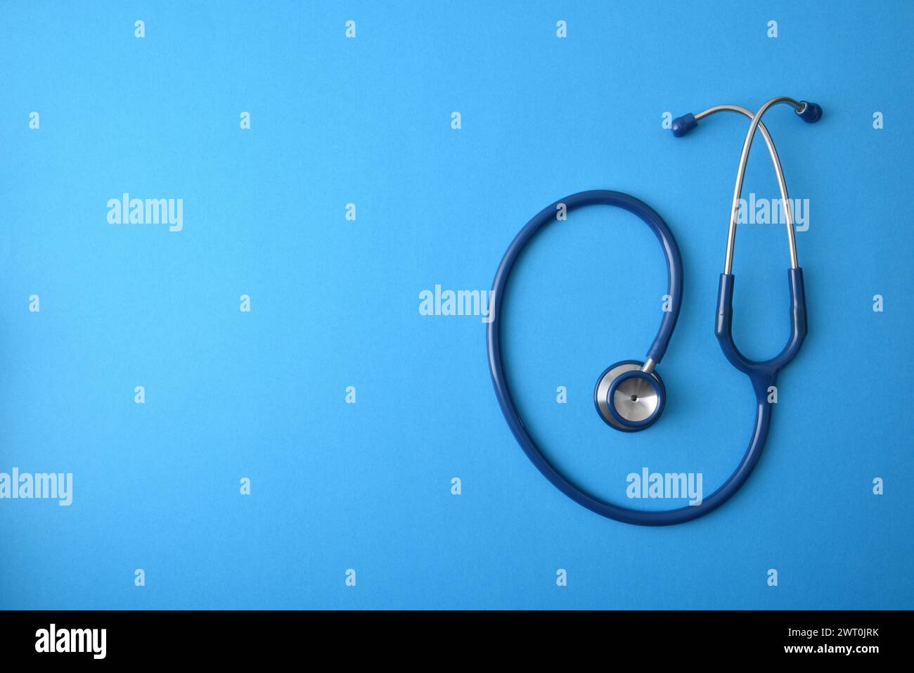 Generischer Gesundheitshintergrund mit Stethoskop isoliert auf blauem Hintergrund. Draufsicht Stockfoto
