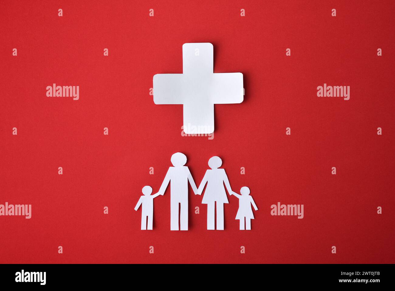 Konzept der Gesundheitshilfe für bedürftige Familien mit Familienausschnitten und Weißbuch-Querschnitt isoliert auf rotem Hintergrund. Draufsicht Stockfoto