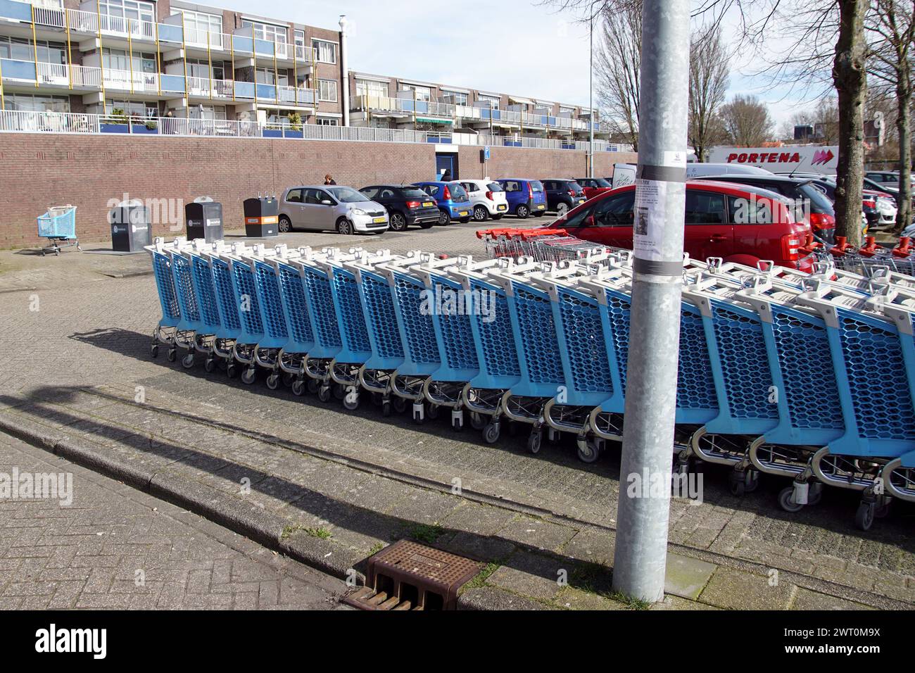 Nahaufnahme einer Reihe blauer Einkaufswagen aus Kunststoff auf der Rückseite eines Einkaufszentrums in der niederländischen Stadt Alkmaar. Appartements, Stockfoto