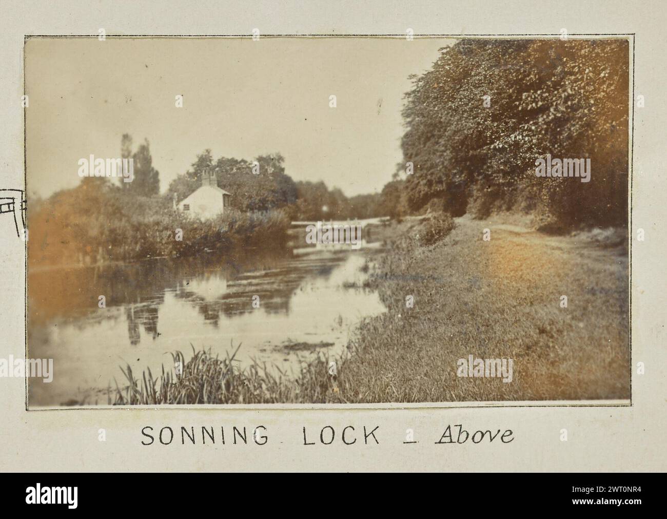 Sonning Lock – Oben. Henry W. Taunt, Fotograf (Britisch, 1842 - 1922) 1897 eines von zwei Fotos mit Tippkarten, die eine gedruckte Karte von Sonning, Shiplake und der Umgebung entlang der Themse zeigen. Das Foto zeigt einen Blick auf den Fluss mit dem Sonning Lock, das in der Entfernung flussabwärts sichtbar ist. Das Schloss Cottage befindet sich am Ufer auf der linken Seite des Bildes. (Recto, Halterung) unten in der Mitte, unter dem Bild, in schwarzer Tinte gedruckt: „SONNING LOCK - above [kursiv]“ Stockfoto