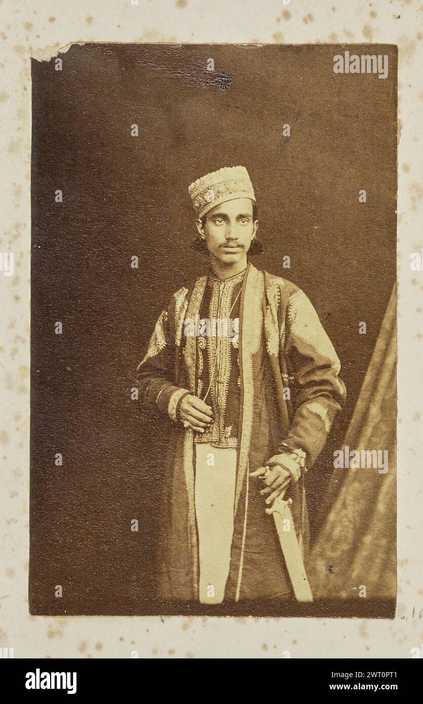 Porträt eines Mannes. Unbekannt, Fotograf 1861–1903 Porträt eines Mannes in einem bestickten Hemd, Mantel und Kopfbedeckung. Er legt eine Hand auf den Griff seines Schwertes. Stockfoto