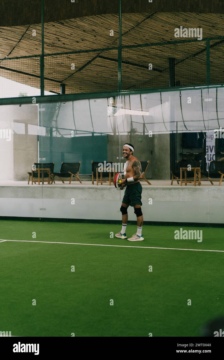 Mann spielt Padel-Tennis auf einem Hallenplatz, Bali. Stockfoto