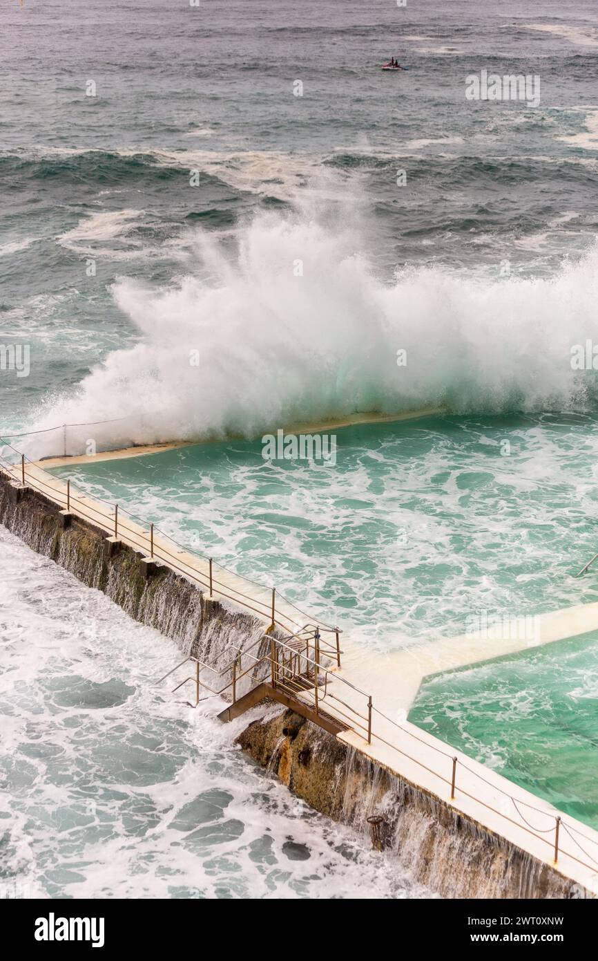 Mächtige Welle stürzt über dem Pool am Meer Stockfoto