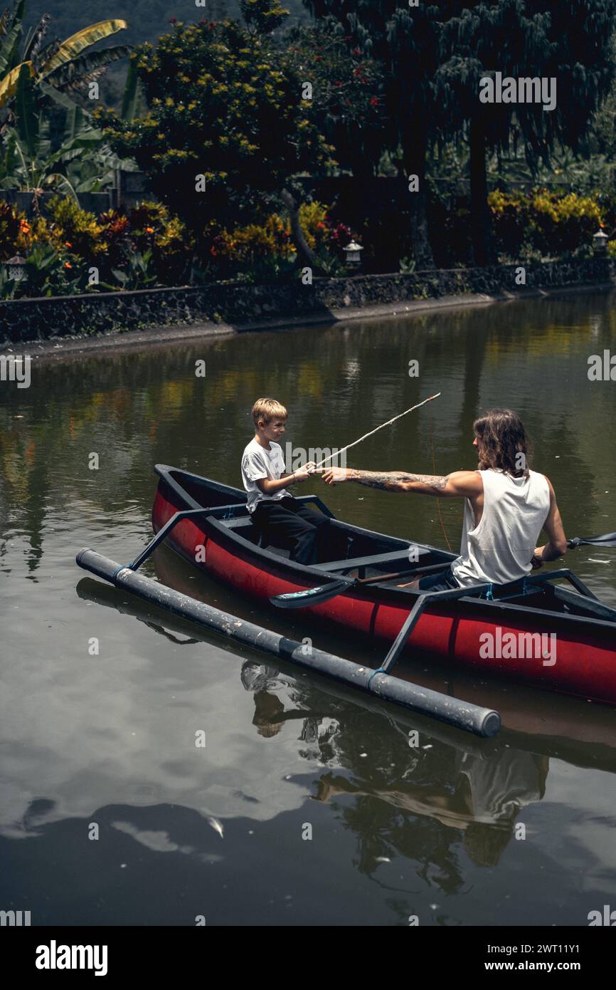 Vater und Sohn fischen auf dem See von einem Boot aus. Stockfoto