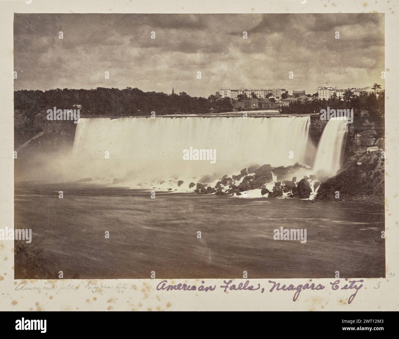 American Falls, Niagara City. Unbekannt, Fotograf 1861–1903 Blick auf die American Falls und die Bridal Veil Falls, Teil der Niagarafälle, von der anderen Seite des Flusses. Eine Reihe von Gebäuden, darunter eines, das mit einer Kuppel gekrönt ist, sind in der Ferne zu sehen. (Recto, Mount) unten links, unten Bild, in Bleistift: 'American Falls [sic] Niagara City.'; unten in der Mitte, unten in lila Tinte: 'American Falls, Niagara City'; unten rechts, unten in Bleistift: '3'; Stockfoto