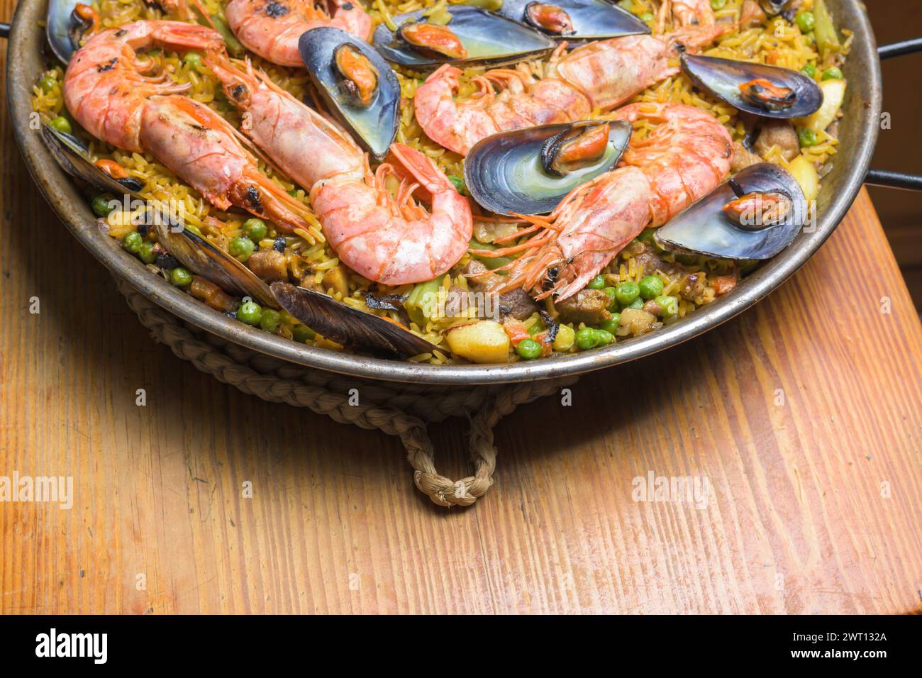 Traditionelle spanische Paella mit Meeresfrüchten auf einem Holzständer Stockfoto