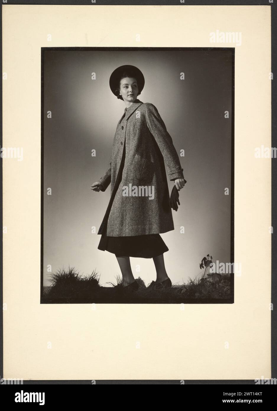 Weibliche Modellierjacke. Günther Krampf, Fotograf (Österreich, 1899–1950) Anfang der 1940er Jahre Porträt einer Frau, die einen Pfaustzug modelliert. Die Frau trägt einen Hut mit kreisförmiger Krempe und hält ein Paar Handschuhe in der Hand. Stockfoto
