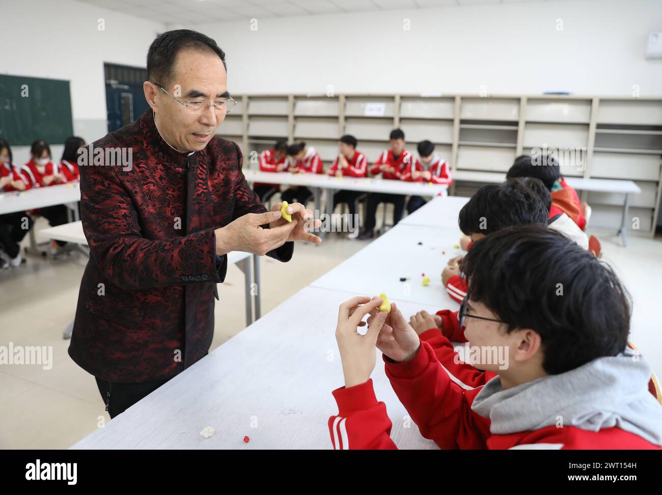 (240315) -- YINGKOU, 15. März 2024 (Xinhua) -- Chen Qunhou unterrichtet Schüler an einer Schule in Yingkou, nordöstlicher Provinz Liaoning, 13. März 2024. Chen Qunhou, 67, ist der Erbe der fünften Generation von Chens Teigskulptur, einer berühmten Teigkunst in Yingkou. Chen hat die Färbetechniken der Teigskulptur verbessert, indem er künstlerische Elemente aus Holzschnitzerei, Tonskulptur, Jadeschnitzerei und Ölmalerei in die traditionelle Kunstform integriert. Er förderte auch die Teigskulpturen in Schulen und Pflegeheimen, um eine tiefere ap zu kultivieren Stockfoto