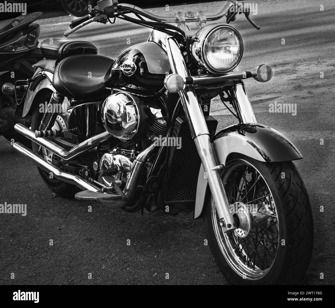 Schwarzes Honda Shadow Cruiser-Motorrad, das am Straßenrand geparkt ist. Motorrad mit verchromtem Motor. Das Motorrad Honda Shadow B Stockfoto