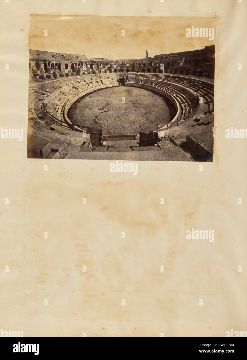 Arènes de Nîmes. Unbekannt, Fotograf 1850er–1890er Jahre Innenansicht des römischen Amphitheaters in Nîmes. Der Turm der Eglise Sainte-Perpétue et Sainte-Félicité ist in der Ferne über der Spitze des Amphitheaters zu sehen. Stockfoto