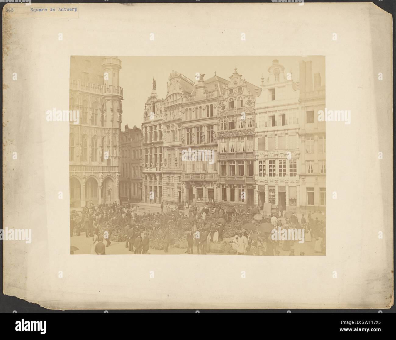Blumenmarkt, Antwerpen. Unbekannt, Fotograf ca. 1865–1885 Ein öffentlicher Platz voller Topfpflanzen und Fußgänger. Männer und Frauen scheinen auf dem Platz Pflanzen zu kaufen, einige tragen Körbe und andere tragen Regenschirme. Die Gebäude rund um den Platz sind mit verschiedenen Skulpturen von Figuren, Adlern und anderen Formen geschmückt. (Recto, Mount) links oben, blau getippter Druck auf Papieretikett: '363 Square in Antwerp'; Stockfoto