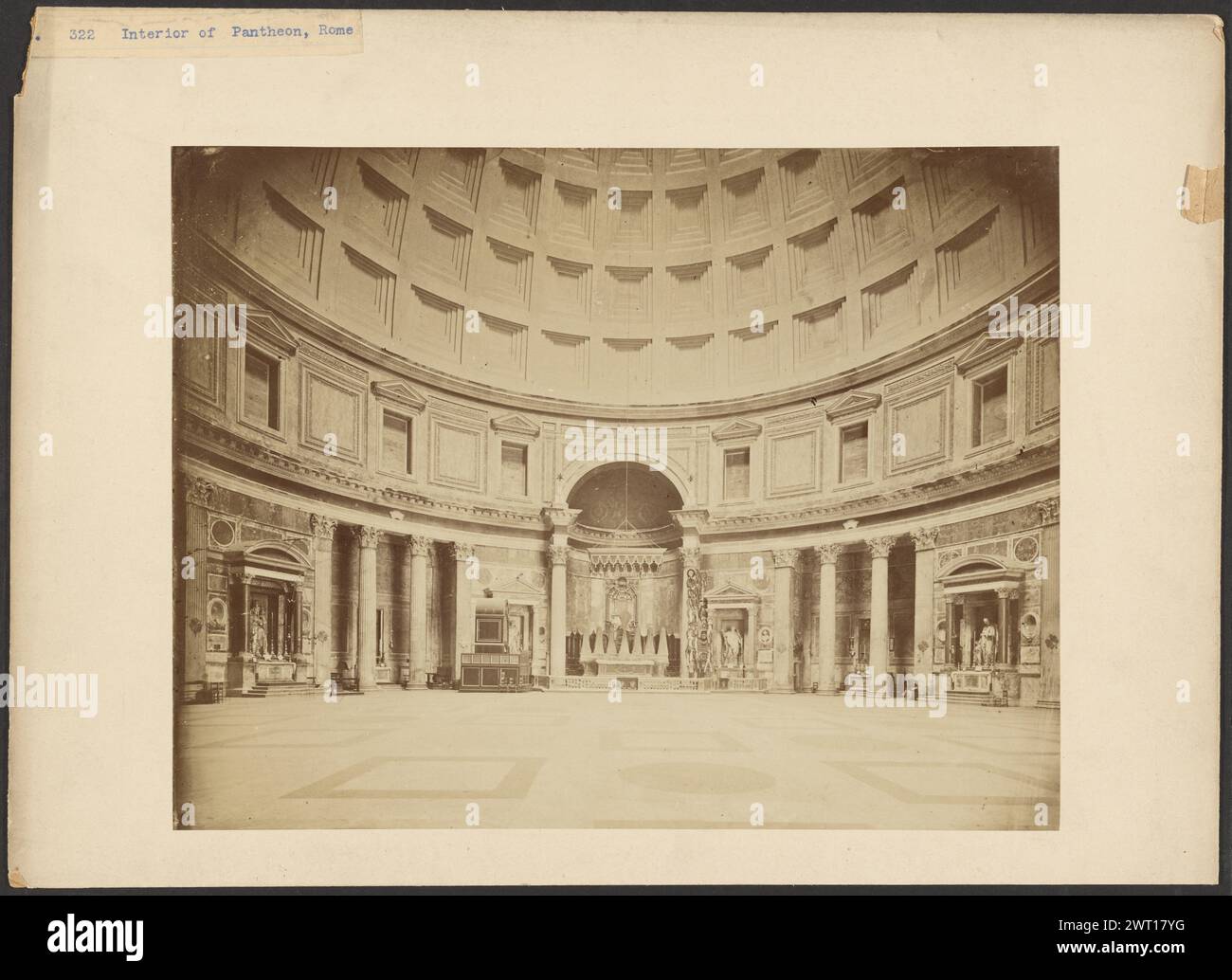 Interno del Pantheon originale, Roma. Unbekannt, Fotograf ca. 1865–1880 Innenansicht des Pantheons mit Blick auf eine bogenförmige Nische. Das gewölbte Dach ist mit Reihen quadratischer Kassen gesäumt. In der Nische befinden sich ein Kronleuchter und ein Altar aus Kandelleuchtern, die jeweils mit einem Blatt bedeckt sind. (Recto, Mount) oben links, blau getippter Druck auf Papieretikett: '322 Interior of Pantheon, Rome'; (Verso, Mount) Mitte, mit der Inschrift im negativ auf dem beigefügten Papier: '32 Interno del Pantheon originale ROMA' Stockfoto Interno del Pantheon originale, Roma. Unbekannt, Fotograf ca. 1865–1880 Innenansicht des Pantheons mit Blick auf eine bogenförmige Nische. Das gewölbte Dach ist mit Reihen quadratischer Kassen gesäumt. In der Nische befinden sich ein Kronleuchter und ein Altar aus Kandelleuchtern, die jeweils mit einem Blatt bedeckt sind. (Recto, Mount) oben links, blau getippter Druck auf Papieretikett: '322 Interior of Pantheon, Rome'; (Verso, Mount) Mitte, mit der Inschrift im negativ auf dem beigefügten Papier: '32 Interno del Pantheon originale ROMA' Stockfoto