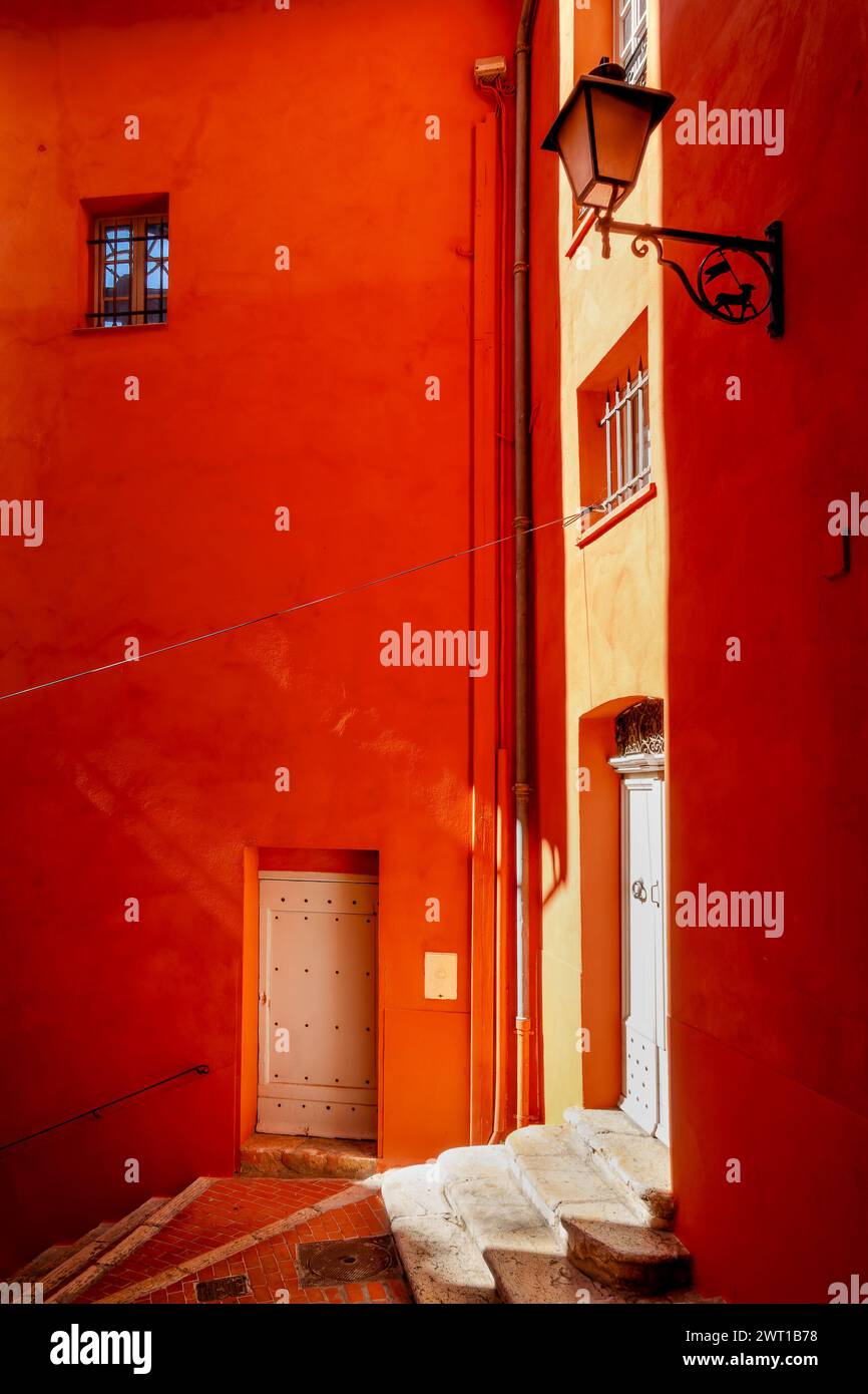 Treppen und orangefarbene Wände in einer Straße in der Altstadt von Grasse in der Provence, Alpes Maritimes, Frankreich Stockfoto