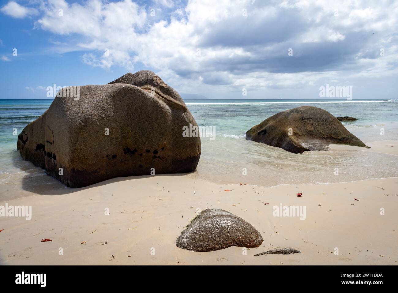 Blick auf die Küste mit weißem Sand und Küstensteinen. Landschaft von Beau Vallon Beach, Seychellen Stockfoto