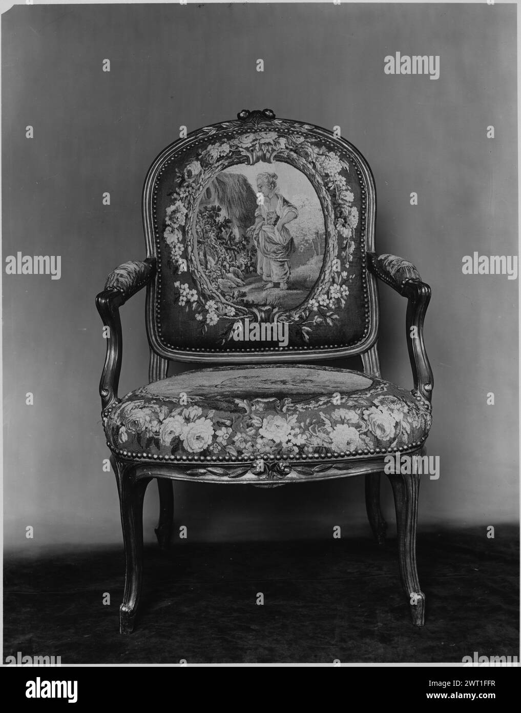 Sessel mit Wandteppich mit weiblicher Figur im Landstrich. Boucher, Francois (französisch, 1703-1770) (entworfen nach) [Maler] Oudry, Jean-Baptiste (französisch, 1686-1755) (entworfen nach) [Maler] unbekannte Tapistik Materialien/Techniken: Unbekannt Kultur: Französisches Weberzentrum: Aubusson Besitz Geschichte: Jacques Seligmann & Co. Gekauft von Mme Vermaut, 2.5.1927; verkauft am 1930, in New York. Gepolsterter Sessel mit Blumengirlande und stechpalme bildendem Medaillon, der eine Bauernin der Landschaft umschließt, und Bauernhaus mit Strohdach im Hintergrund der Sessel ist Teil eines 6er-Sets. A Nein Stockfoto