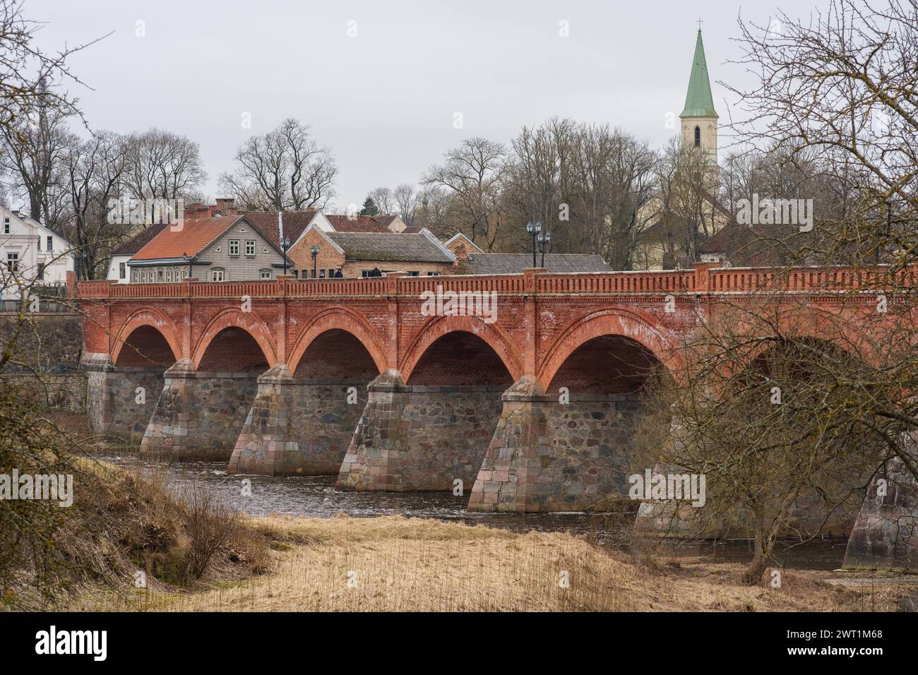 Eine Brücke, die mit Geschichten aus vergangenen Jahrhunderten gewebt ist, erzählt die Schönheit von Kuldiga aus roten Ziegeln Geschichten über lettisches Erbe und Widerstandsfähigkeit Stockfoto