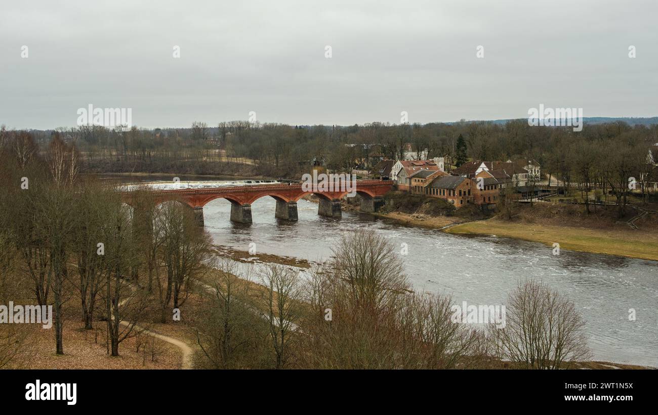 Erfassen Sie das Wesen der lettischen Architektur, während Sie die rustikale Eleganz der roten Backsteinbrücke von Kuldiga erkunden, ein wahres Juwel der Vergangenheit Stockfoto