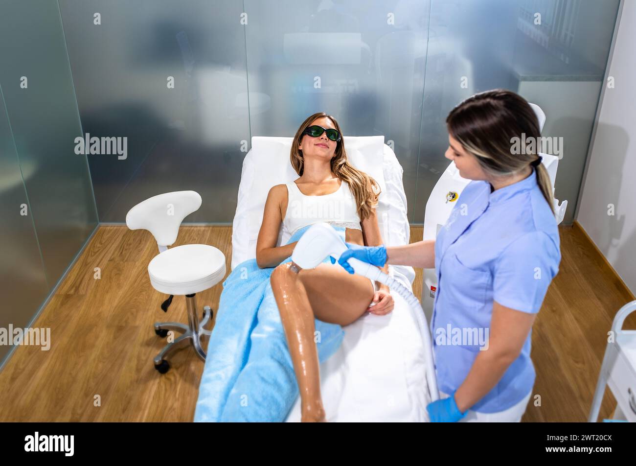 Die Frau in einem Schönheitssalon entfernt ihr Bein mit Laserepilierung. Stockfoto