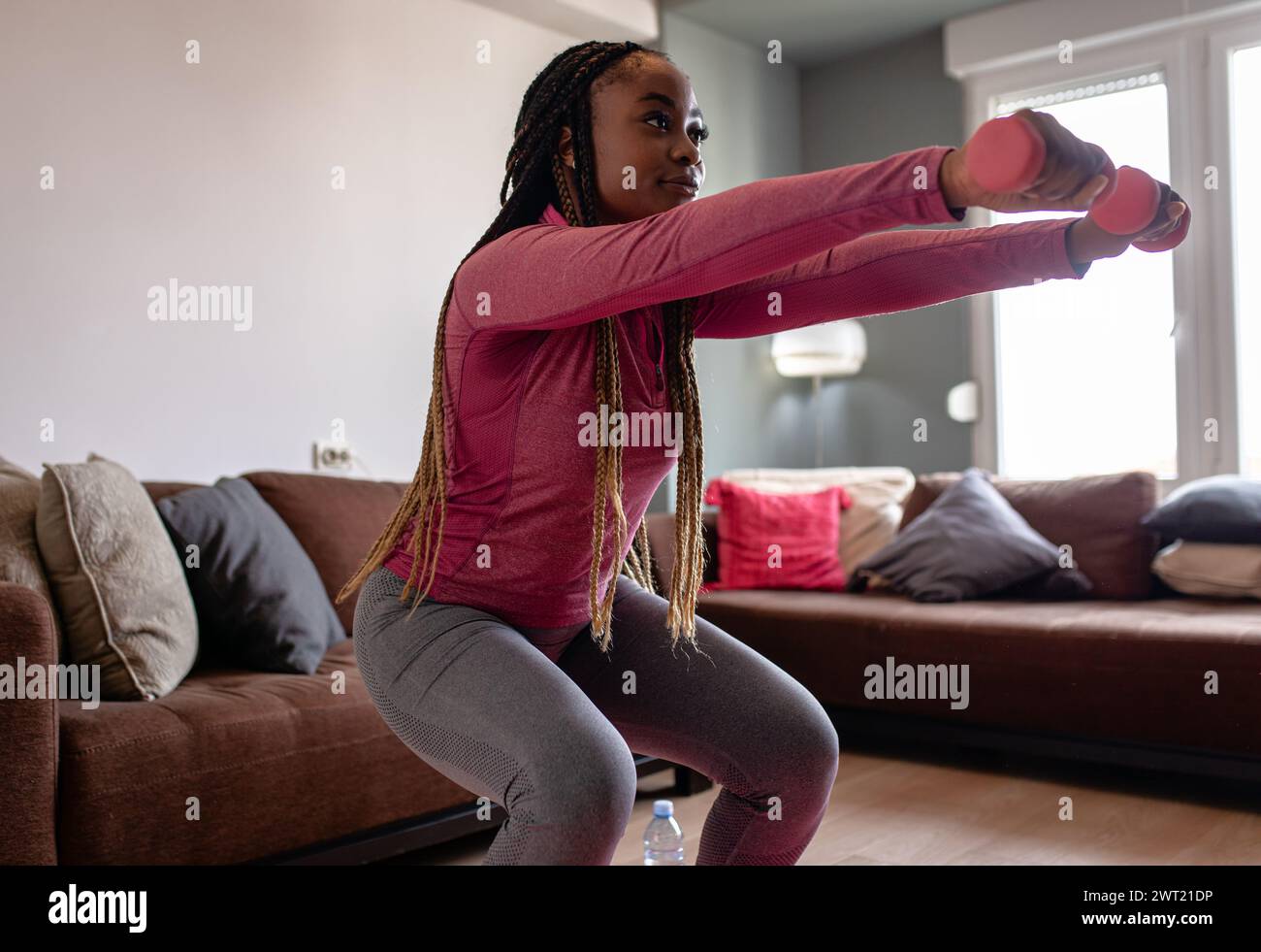Porträt einer jungen afroamerikanischen Frau zu Hause, die Sport macht. Stockfoto