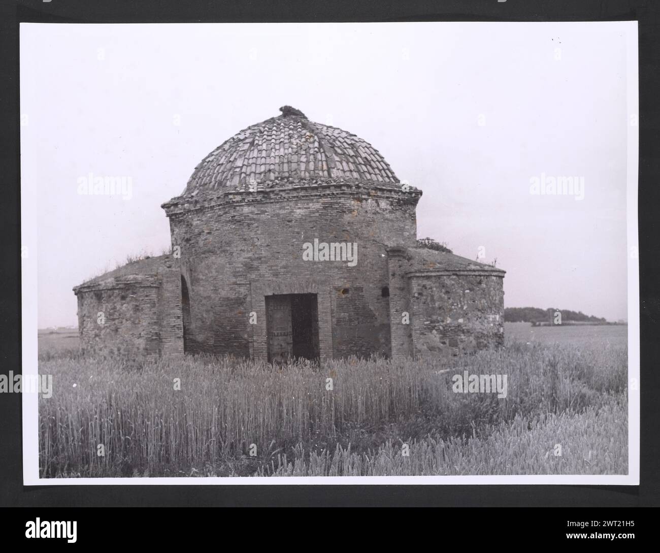 Latium Roma Pratica di Mare Heroon di Enea. Hutzel, Max 1960-1990 Antiquities: Backstein aus dem 4. Jahrhundert, polygonale Struktur. Erbaut über dem 7. Jh. v. Chr. Tumulus, gilt als das Grab von Aeneas. Der in Deutschland geborene Fotograf und Gelehrte Max Hutzel (1911–1988) fotografierte in Italien von den frühen 1960er Jahren bis zu seinem Tod. Das Ergebnis dieses Projektes, von Hutzel als Foto Arte Minore bezeichnet, ist eine gründliche Dokumentation der kunsthistorischen Entwicklung in Italien bis zum 18. Jahrhundert, darunter Objekte der Etrusker und Römer sowie frühmittelalterliche, romanische, gotische, Renaissance- und Barockdenkmäler. Im Stockfoto