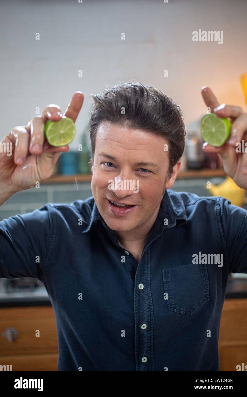 Jamie Oliver, englischer Starkoch, Restauranteur, der zwei Limetten in die Hände quetscht. Stockfoto