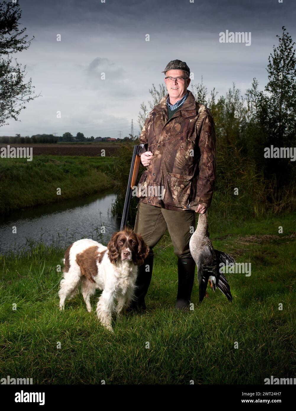 Hunter mit seinem Hund mit einer Gans in der Hand. Niederlande. Vvbvanbree-Fotografie Stockfoto