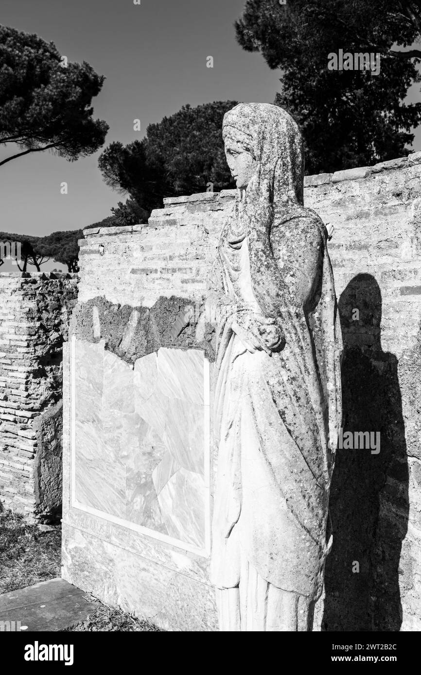Schwarz-weiß-Foto einer antiken römischen Statue in Ruinen, die das Profil einer Frau zeigt, die einen Schleier trägt Stockfoto