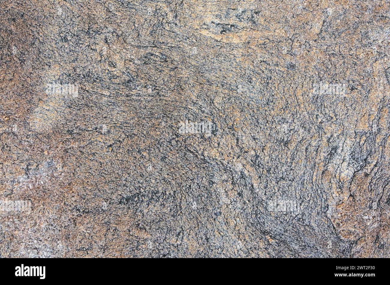 Detaillierte Nahaufnahme einer strukturierten Granitoberfläche, die die komplizierten Muster und Farben des Natursteins zeigt. Stockfoto