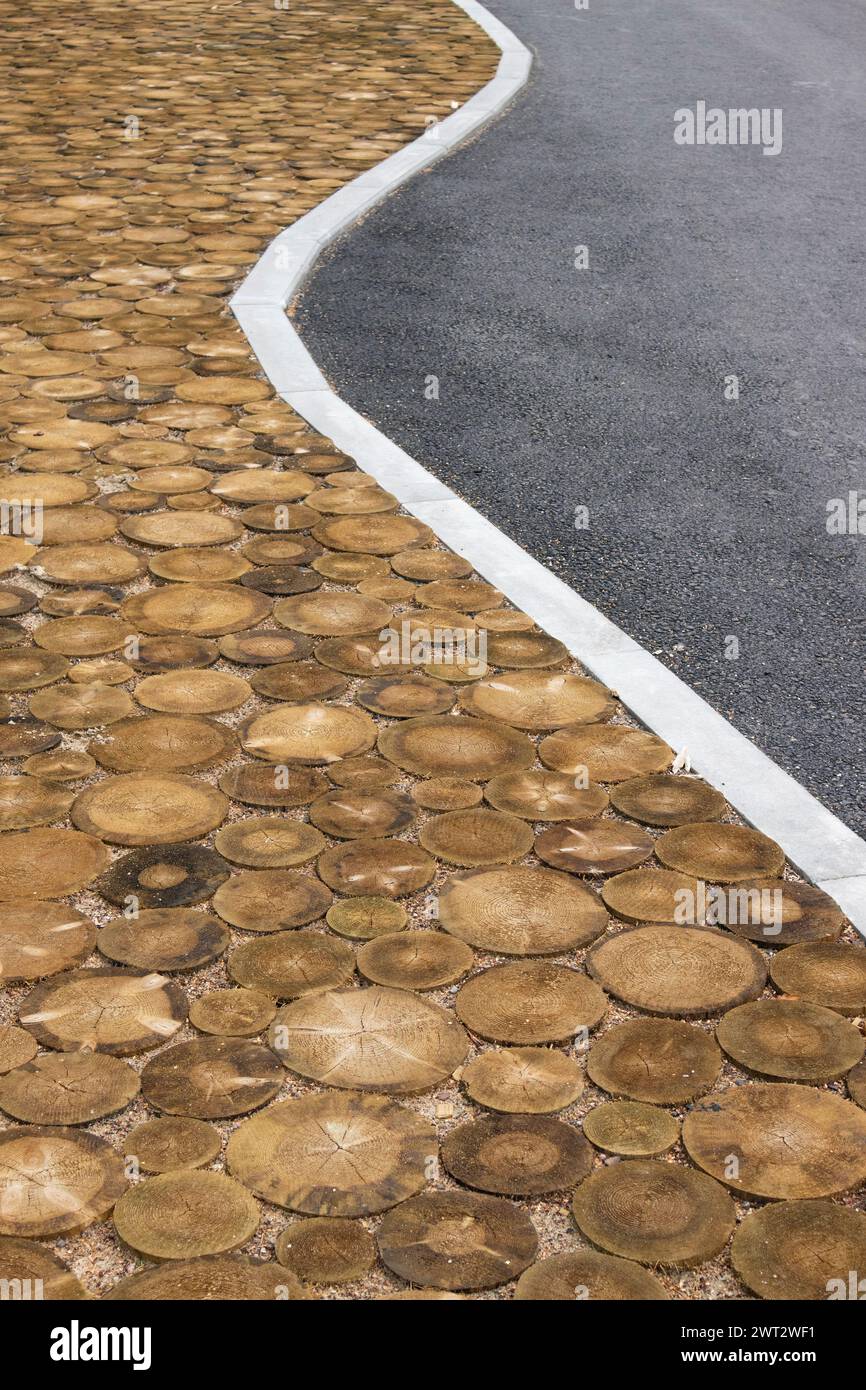 Mischen verschiedener Materialien auf Straßenstraßen im Freien. Holzscheiben mit Asphalt. Stockfoto