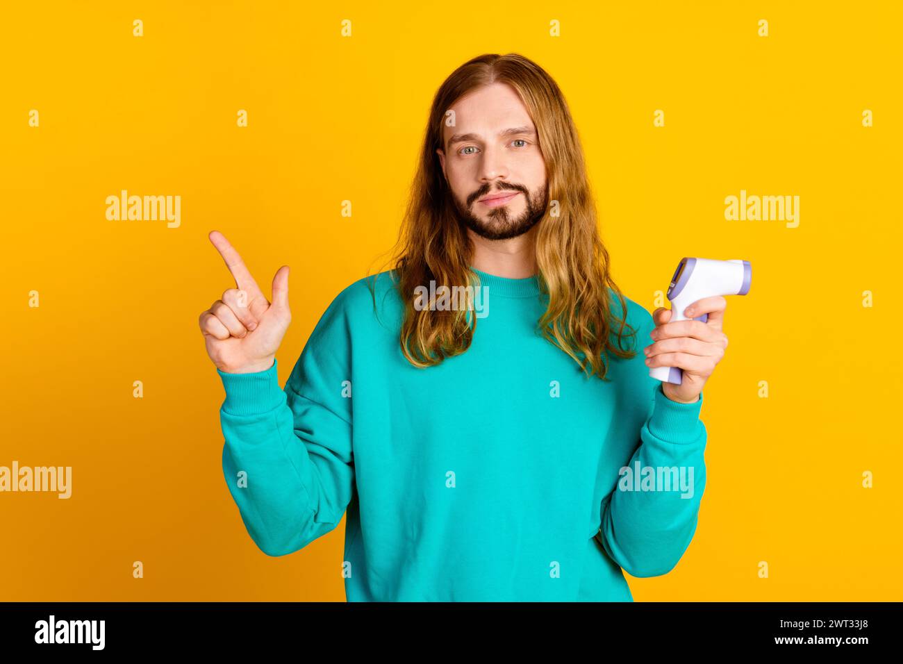 Porträt eines attraktiven Guy Hold Thermometers zeigt den leeren Finger auf gelbem Hintergrund Stockfoto