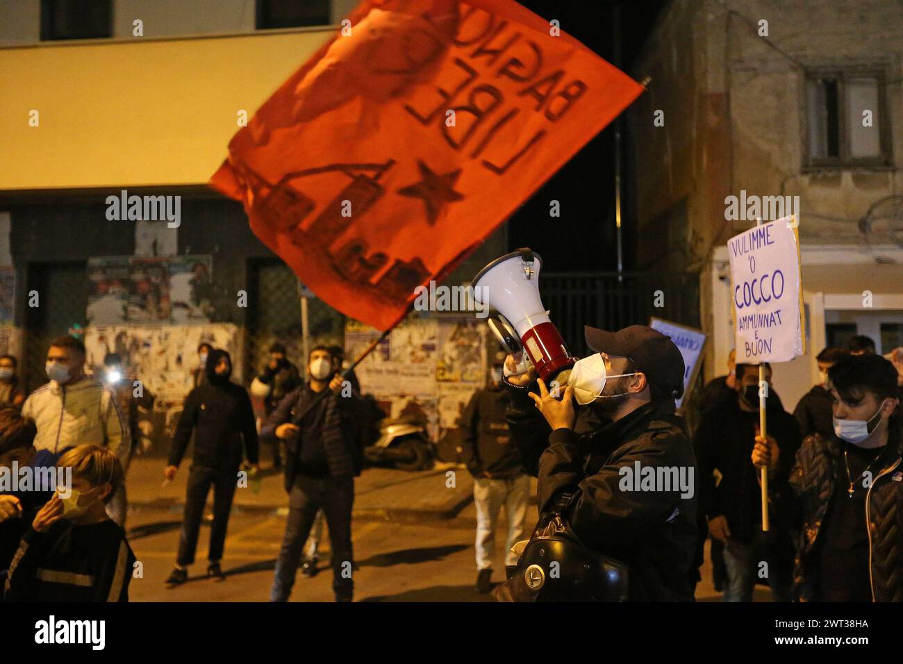 Menschen mit Plakaten protestieren mit einem Megaphon und einer roten Flagge gegen die teilweisen Lockdown-Maßnahmen der italienischen und der Regionalregierung, die dafür ergriffen wurden Stockfoto