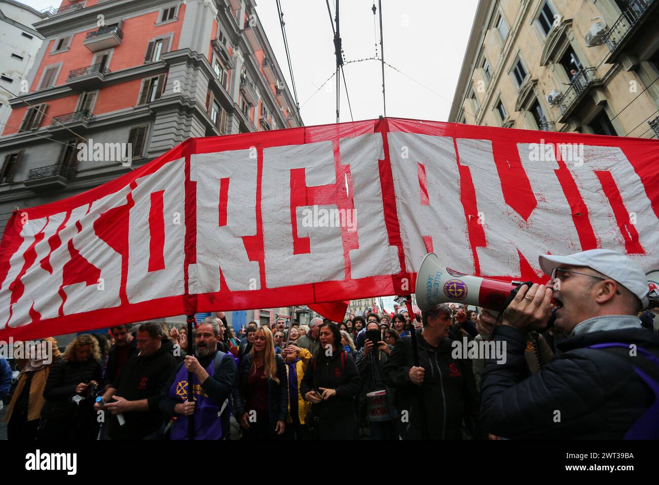 Menschen mit einem Banner und einem Megaphon, während der Demonstration in Neapel "Wir erheben uns", um gegen die Inflation, die hohen Energiepreise und Th zu protestieren Stockfoto