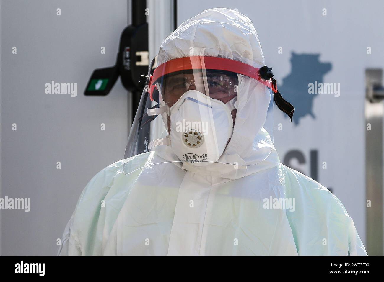 Ein Arzt, der sich in Overall und Masken verkleidet, um sich zu schützen, wartet im Innenhof eines Krankenhauses auf Menschen, die den Test für das Dekor durchführen müssen Stockfoto