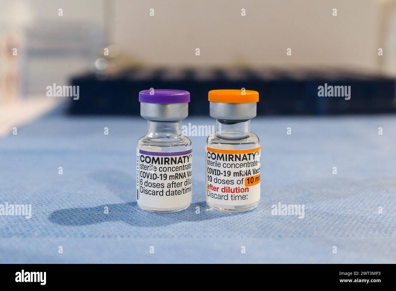 Zwei Durchstechflaschen mit Pfizer Comirnaty Impfstoff: Die eine mit der Kappe für die Impfung von Erwachsenen und die andere mit der orangefarbenen Kappe für die Impfung von Kindern. Stockfoto