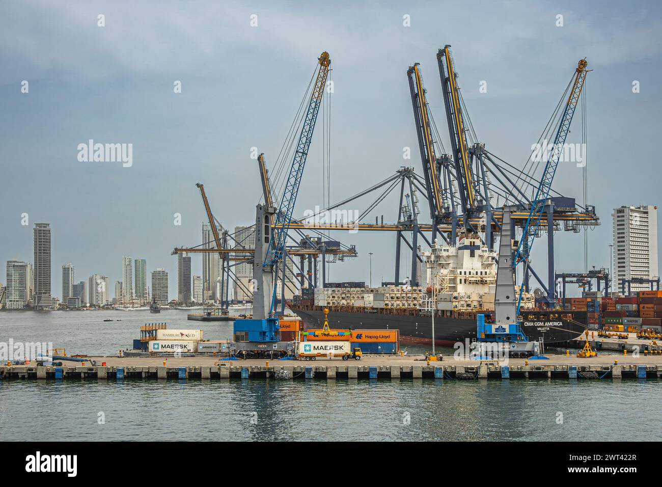 Cartagena, Kolumbien - 25. Juli 2023: Blick nach osten vom SPRC-Containerterminal mit funktionierendem Schiff, Kränen und Anlegerstapeln. Hohes, modernes Design Stockfoto