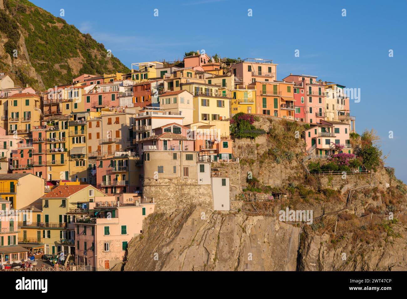 Manarola, IT - 26. Juli 2023: Bunte Häuser im Dorf Manarola während der goldenen Stunde Stockfoto