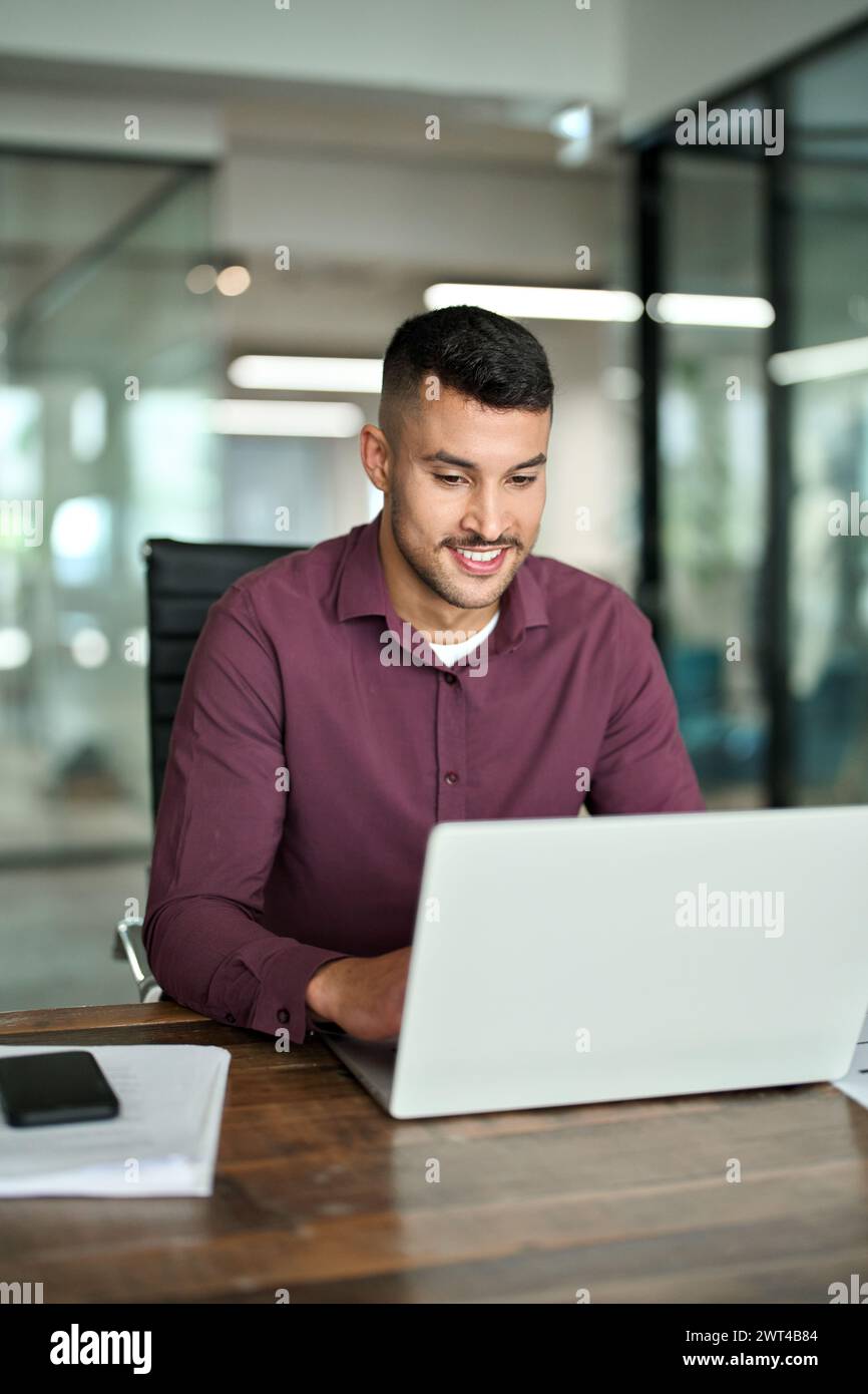 Lächelnder geschäftiger Geschäftsmann, Firmenangestellter mit Laptop, der im Büro arbeitet. Stockfoto