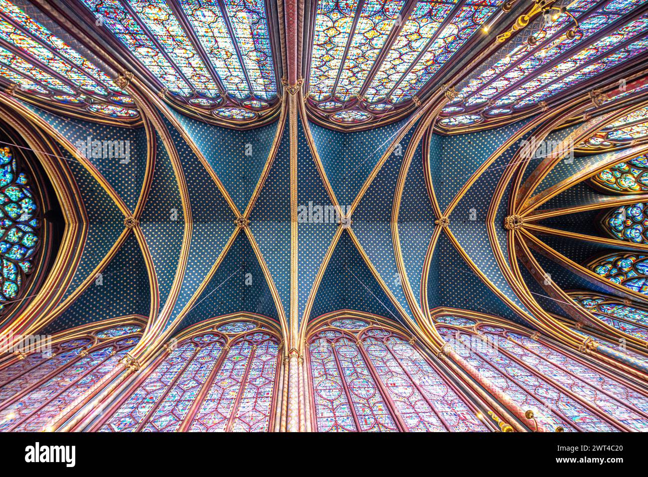 Gewölbedecke und Buntglasfenster der Sainte Chapelle, Paris, in farbenfrohes Licht getaucht. Stockfoto