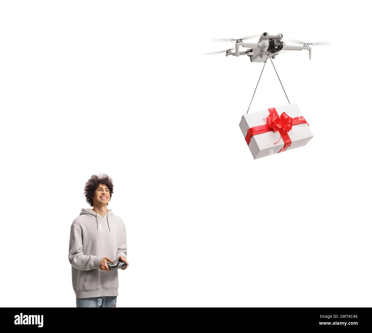 Glücklicher junger Mann, der eine Geschenkbox mit einer Drohne auf weißem Hintergrund liefert Stockfoto