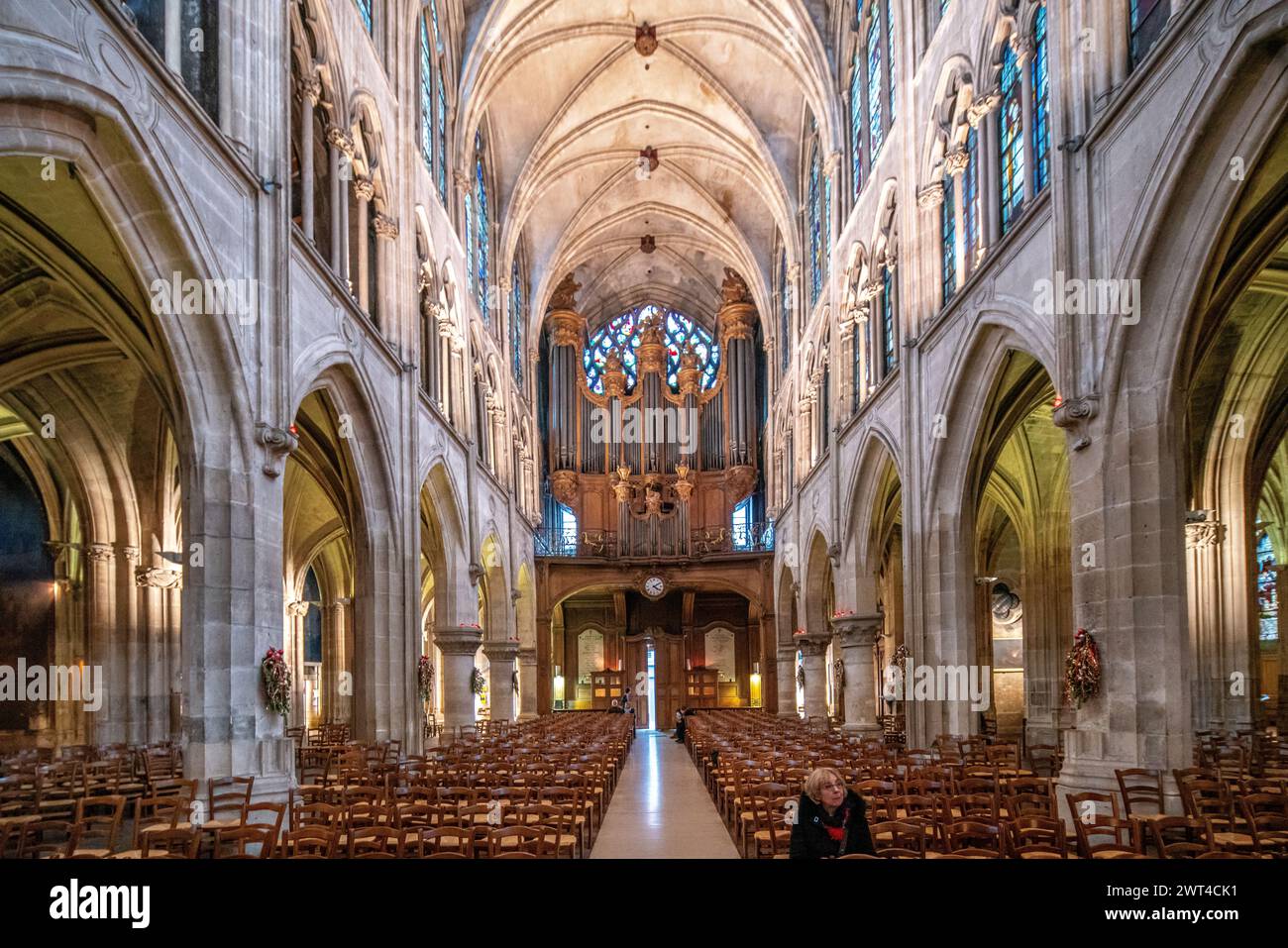 Ruhiges Ambiente in der Kirche Saint Severin in Paris mit Abendlicht, das durch Buntglas gefiltert wird. Stockfoto