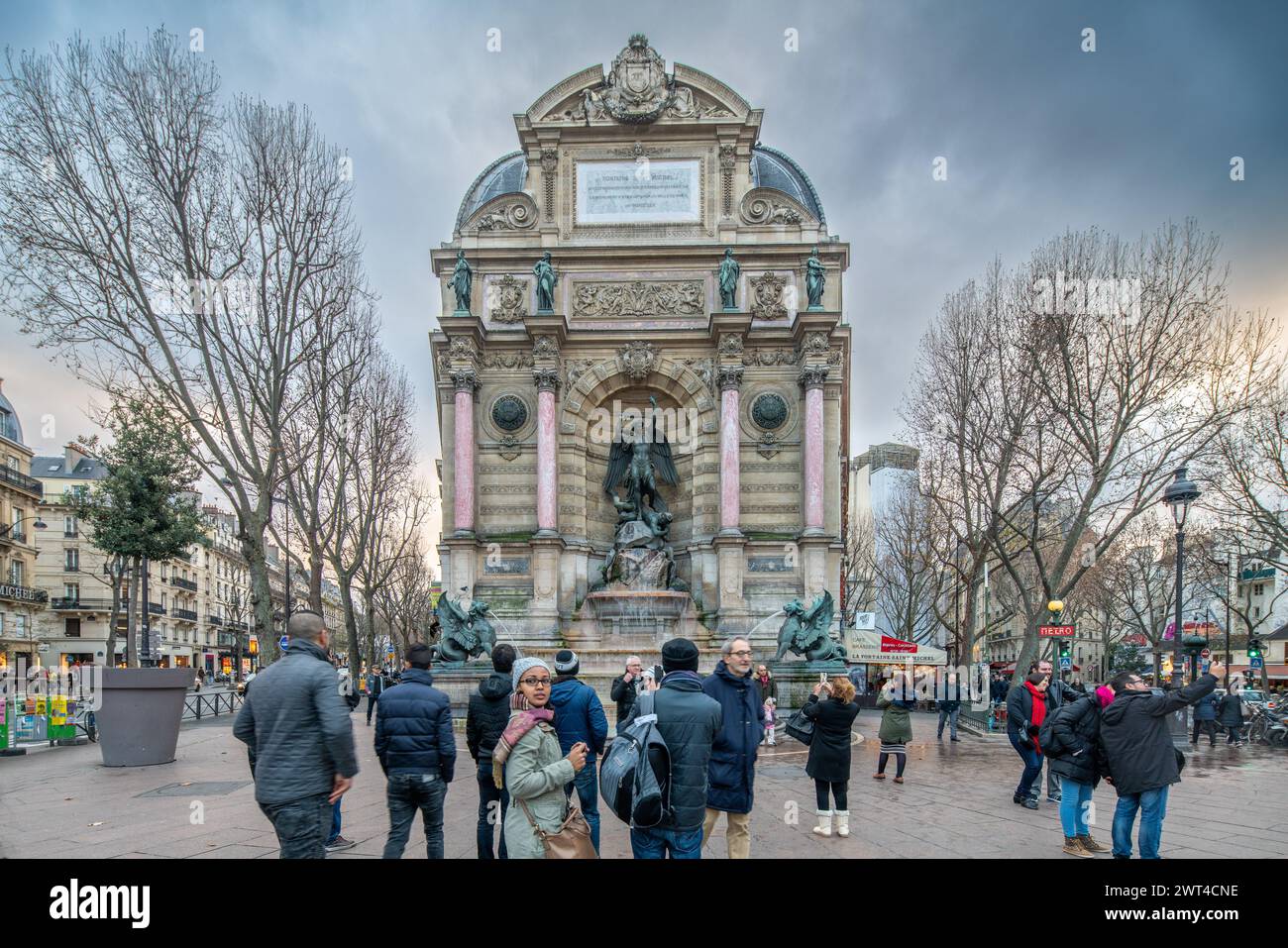 Touristen treffen sich am Abend um den berühmten Saint-Michel-Brunnen in Paris. Stockfoto