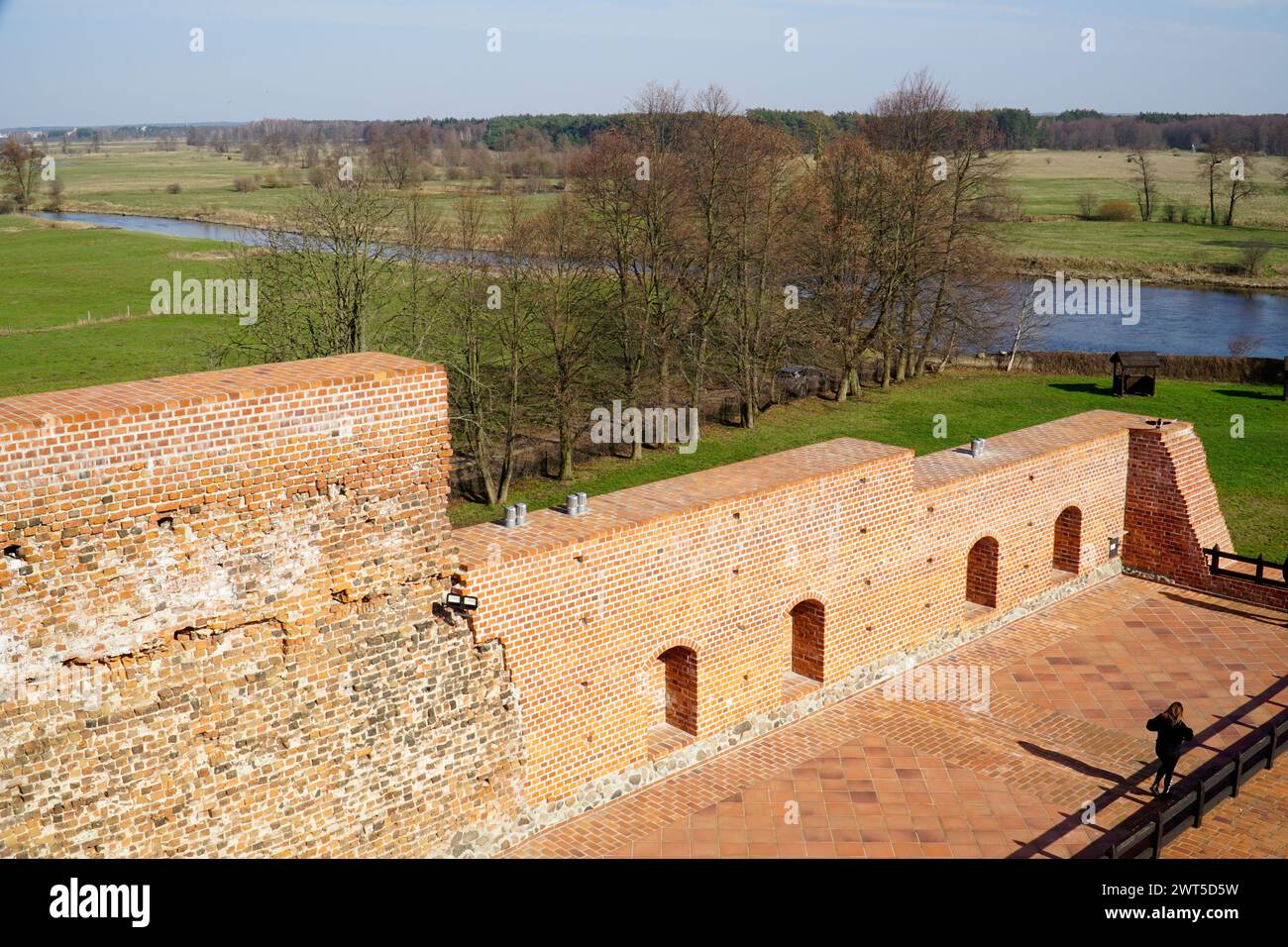 LIW, Polen - 10. März 2024 - mittelalterliche Mauern der herzoglichen Burg, Felder und Fluss Liviec Stockfoto