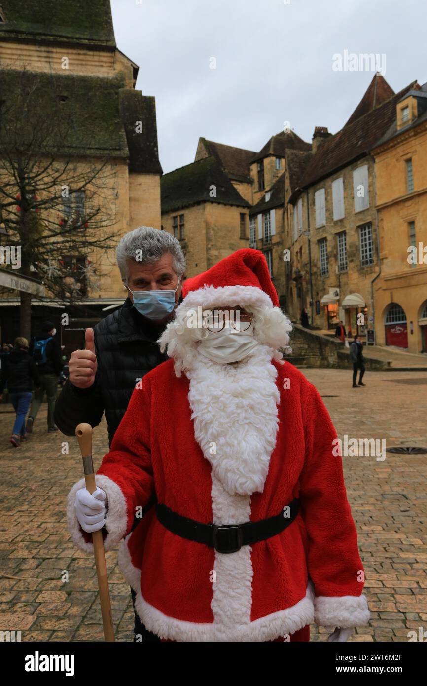 Santa Claus und COVID-19. Der Weihnachtsmann trägt während der COVID-19-Pandemie eine Schutzmaske. Sarlat-la-Canéda, Périgord Noir, Dordogne, Frankreich, EU Stockfoto