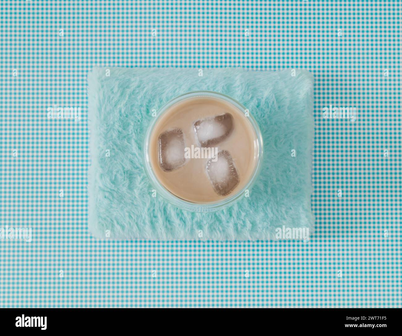 Trendige Anordnung einer Tasse Eiskaffee auf pastellblauem Kunstfellhintergrund. Minimales Kaffeekonzept. Kreative Idee für Eiskaffee im Sommer. Flache Lagen. Stockfoto