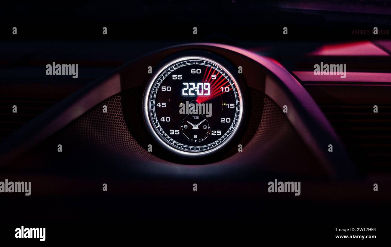 Porsche Sport Chrono Uhr. Uhr im Fahrzeuginnenraum zeigt 22:09 Uhr an – Langzeitbelichtung bei Nacht mit verschwommenem Sekundenzeiger. Stockfoto